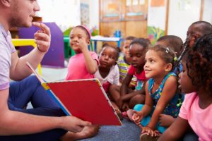 children listening to a care provider reading