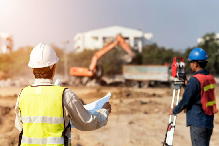 GC looking at blueprints on construction site