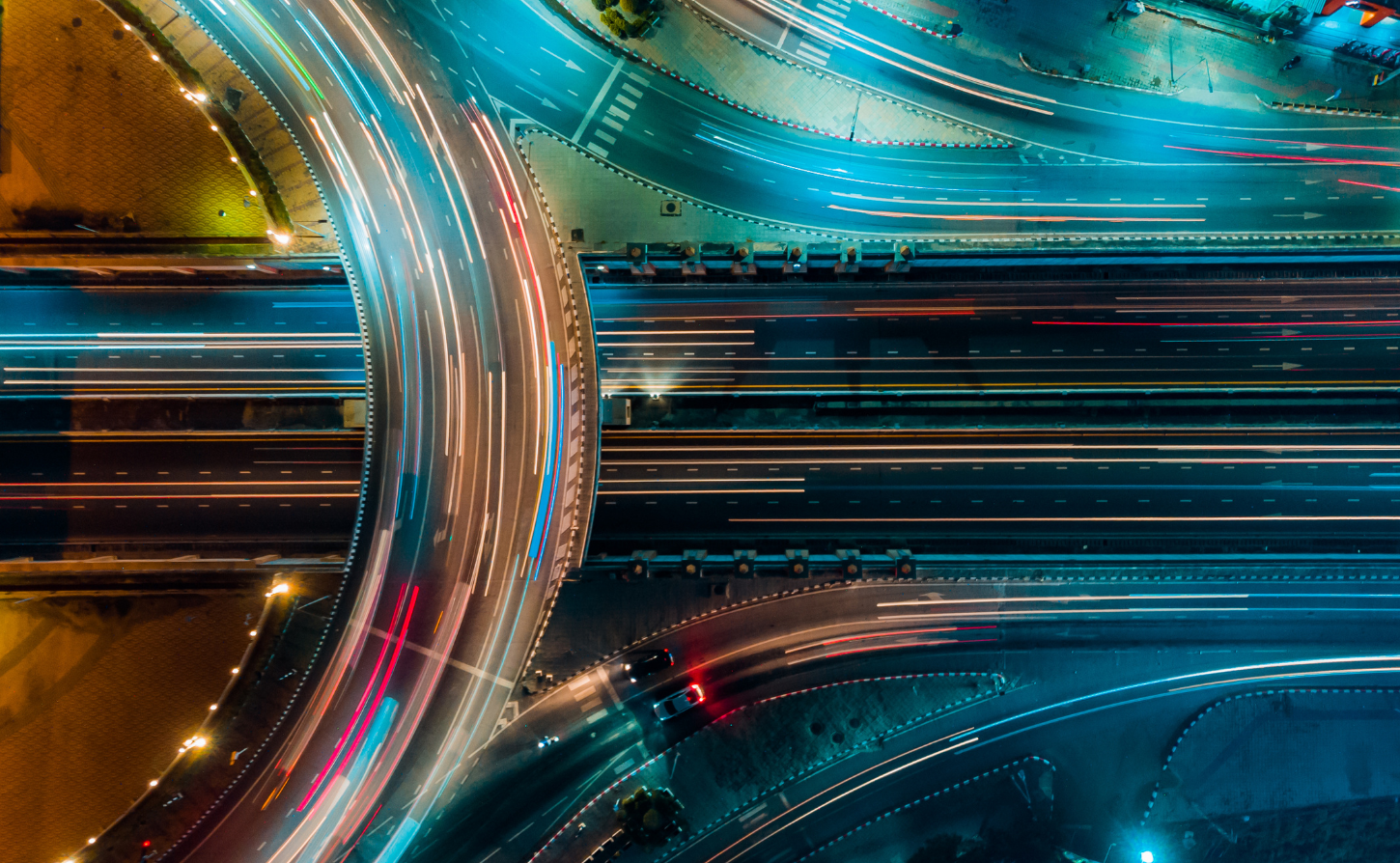 birds eye view of roadway at night with lots of lights showing cars in motion