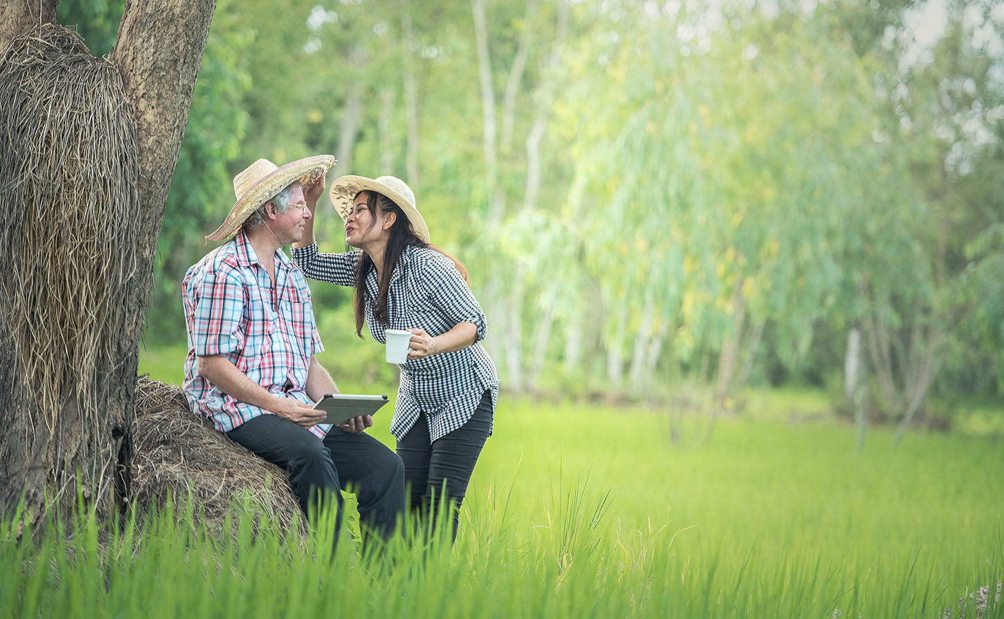 couple wearing straw hats about to embrace