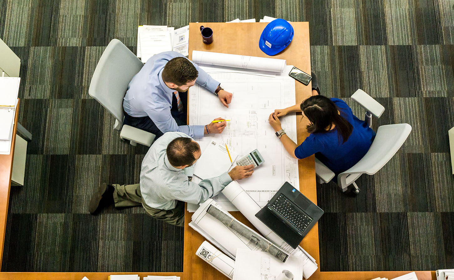 2 workers in an office looking at blueprints