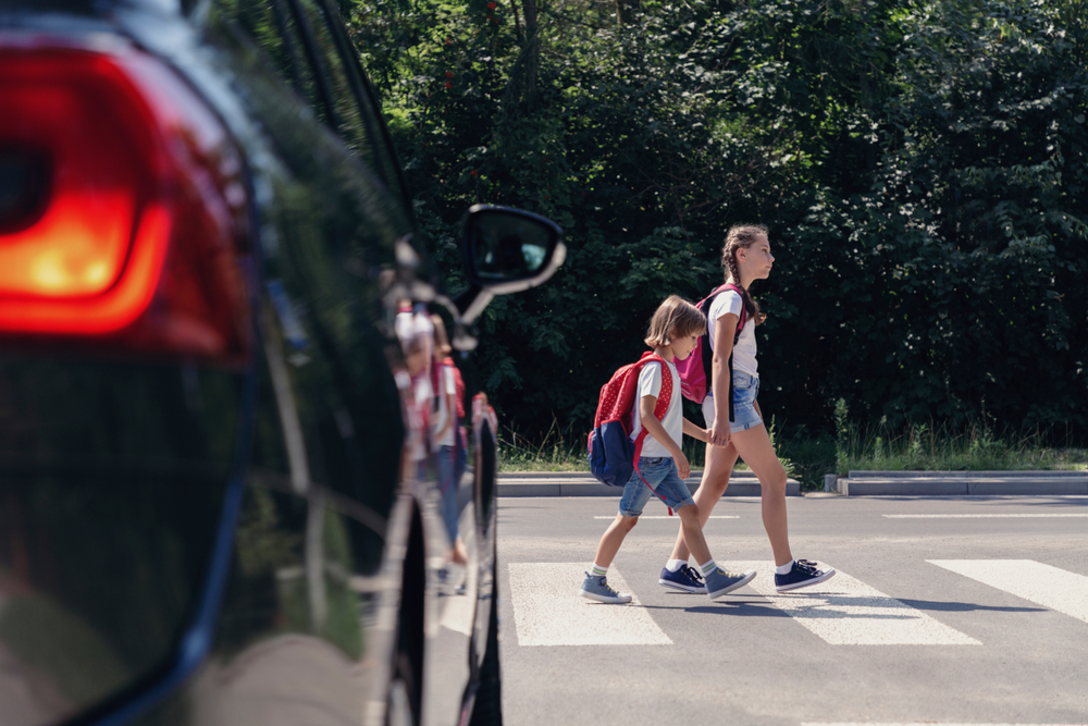 two kids crossing at a crosswalk
